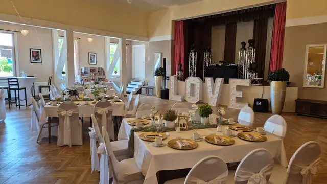 Hochzeitssaal mit leuchtenden LOVE-Buchstaben vor der Bühne